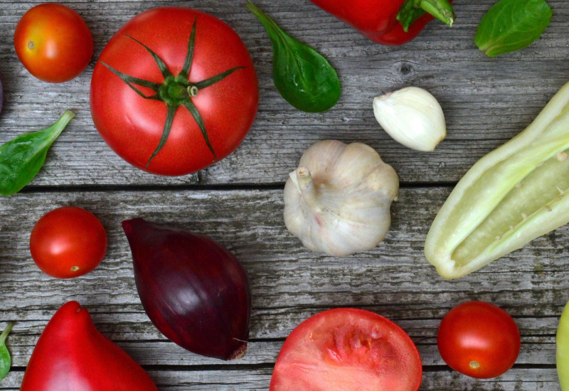 Gambar latar pelbagai sayur-sayuran import seperti kobis, bawang, dan tomato di pasaran.