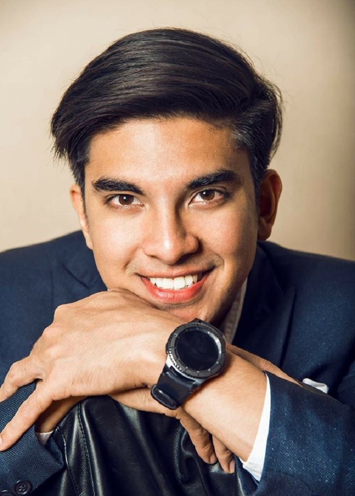 Syed Saddiq berdiri tersenyum