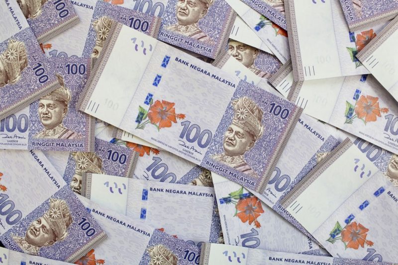 Tiga keping wang kertas ringgit Malaysia dilipat bersama gulungan syiling menunjukkan cara simpan duit.