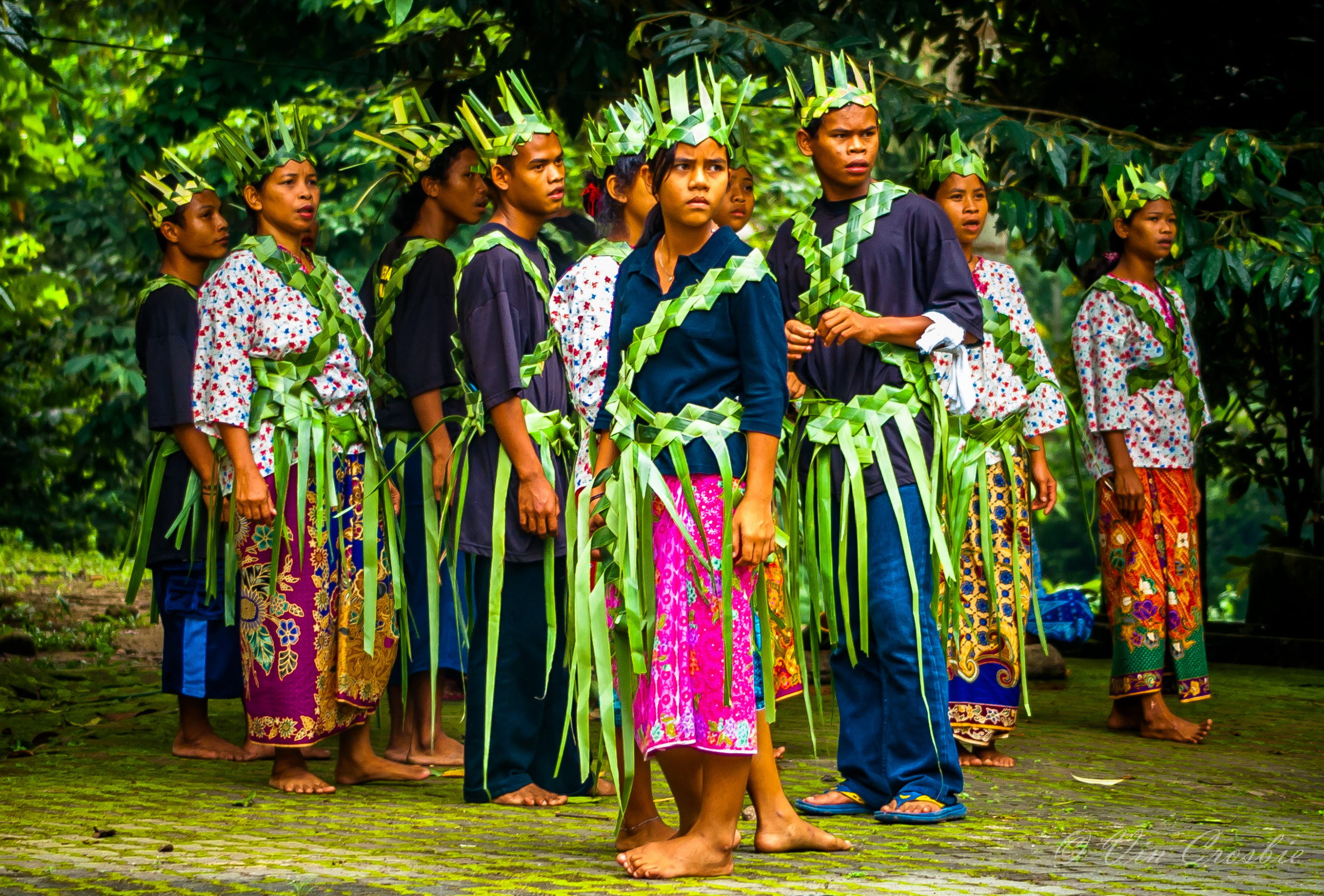 Sekumpulan masyarakat Orang Asli di Malaysia berdiri di hadapan rumah tradisional di kawasan hutan.