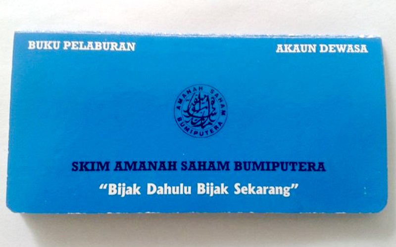 Buku dan dokumen Amanah Saham Bumiputera (ASB) atas meja.