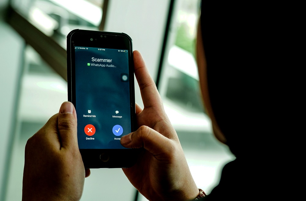 Imej ilustrasi individu yang menjadi mangsa scam dan kelihatan terkeliru dengan telefon bimbit.