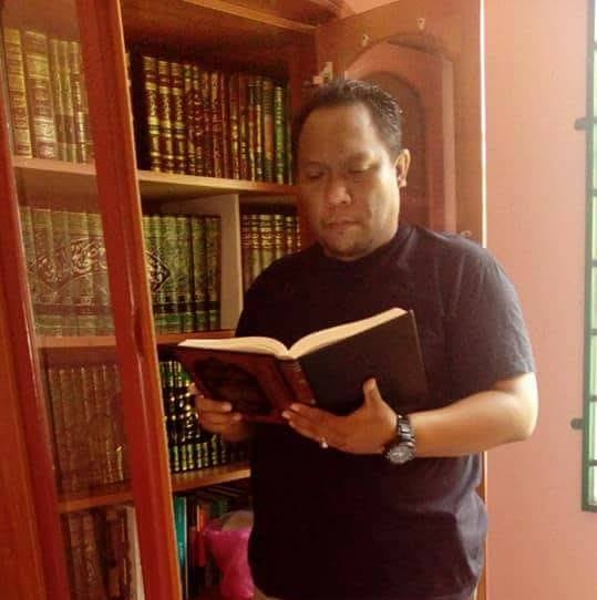 Potret Ustaz Auni bersama koleksi bukunya.